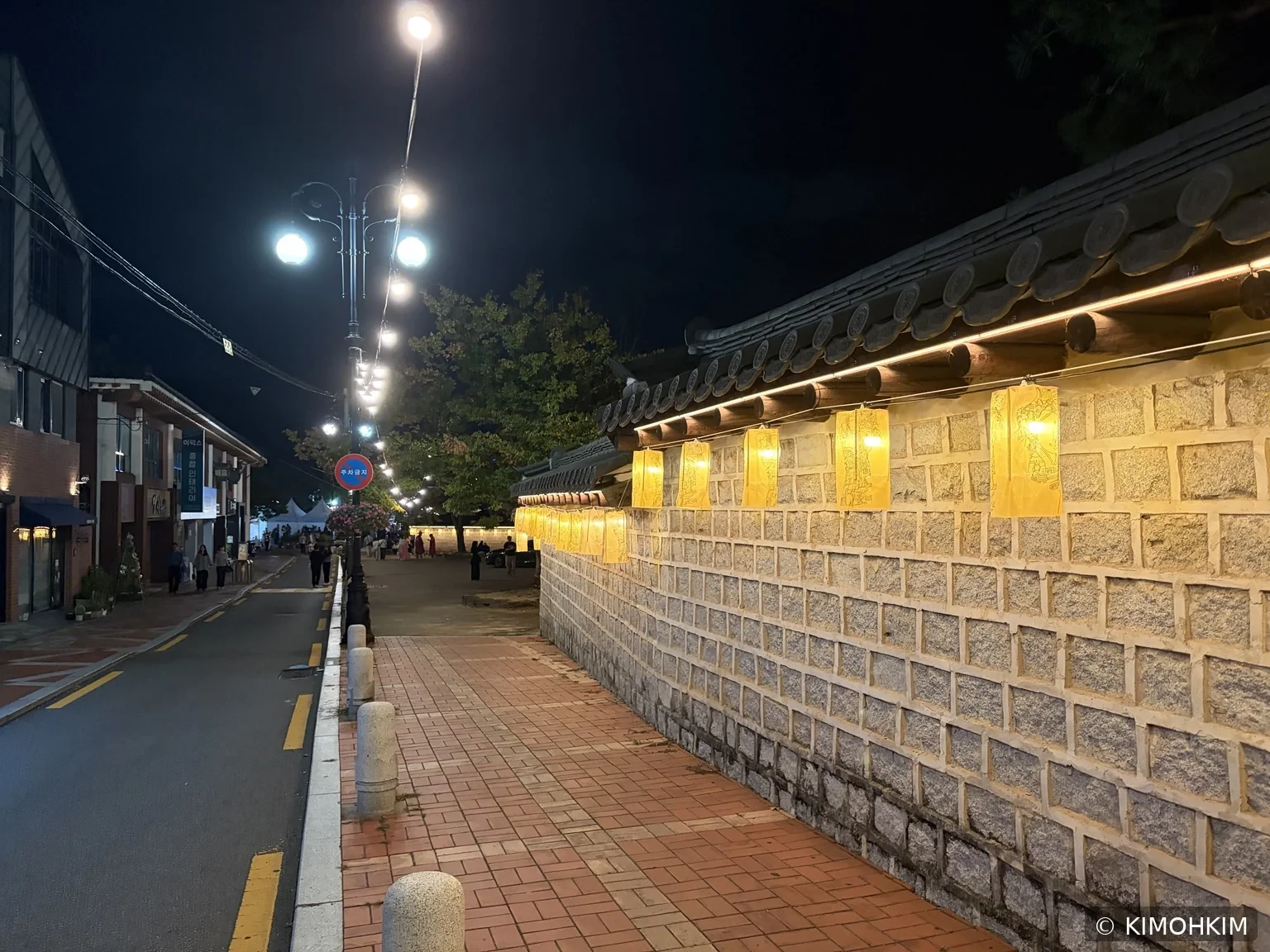 따뜻한 조명이 걸린 김해 왕릉길 돌담